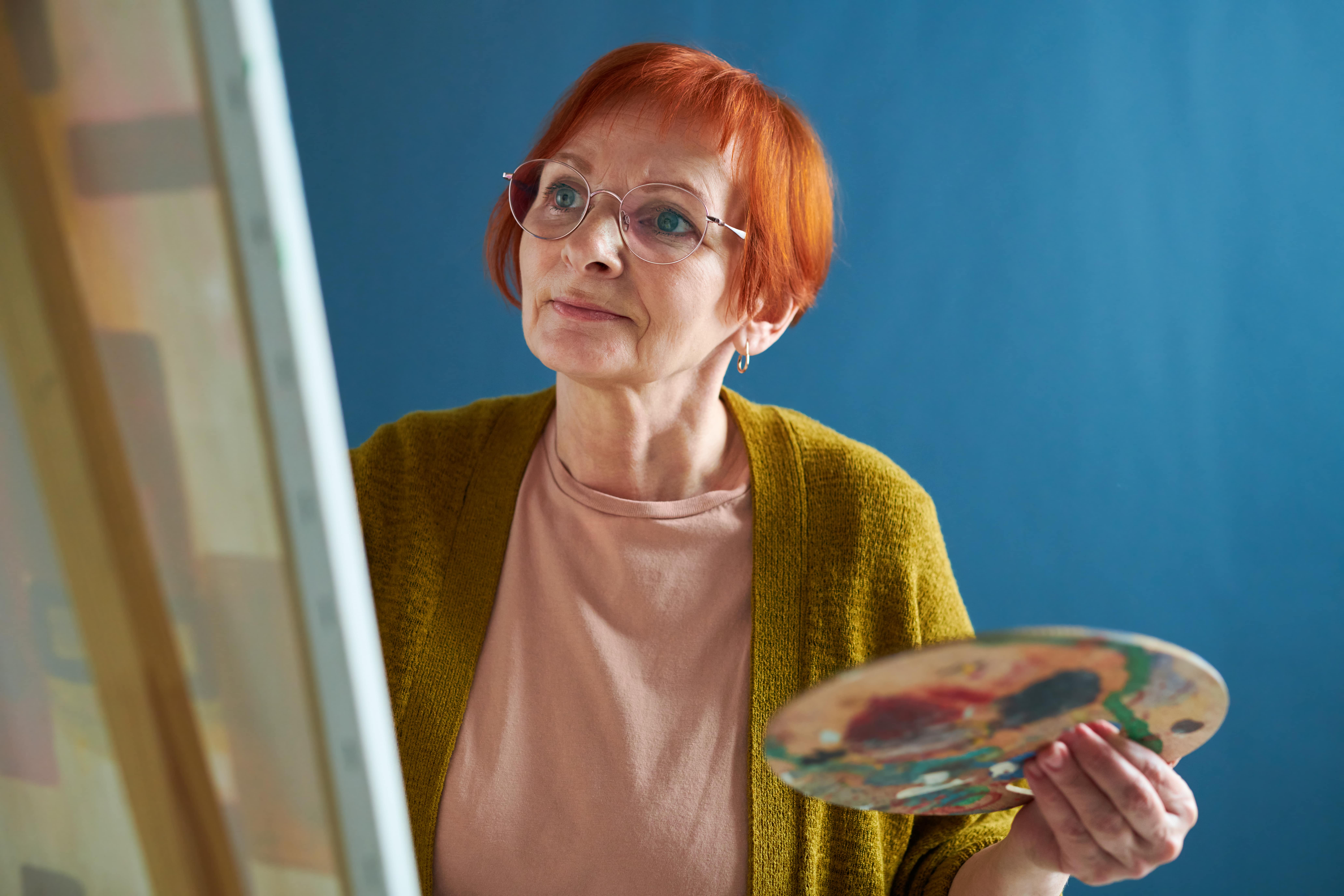 senior-woman-enjoying-painting-on-easel-2022-05-30-20-21-43-utc-min
