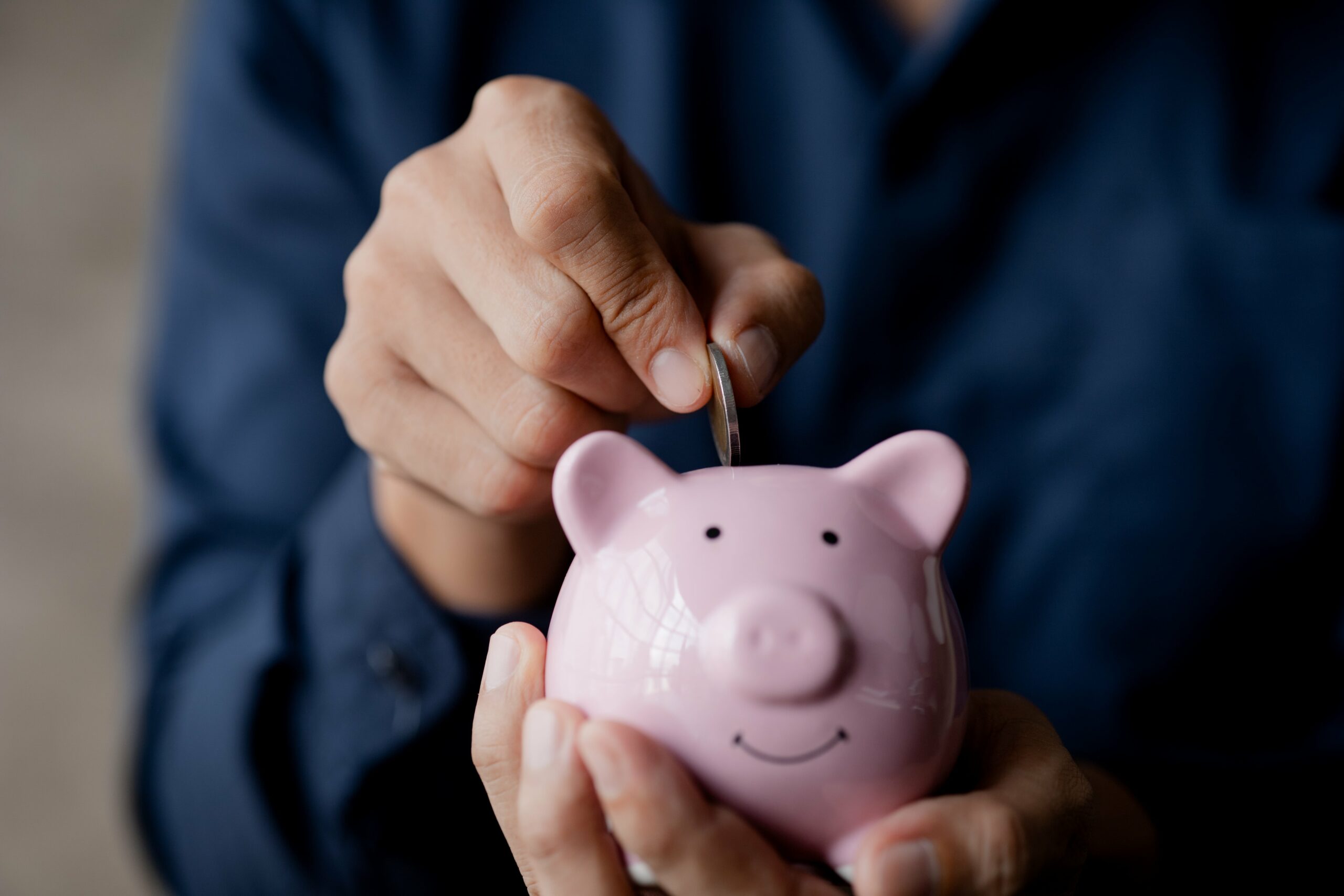 a-businessman-holding-a-coin-in-a-piggy-bank-2023-11-27-05-20-11-utc-min (1)