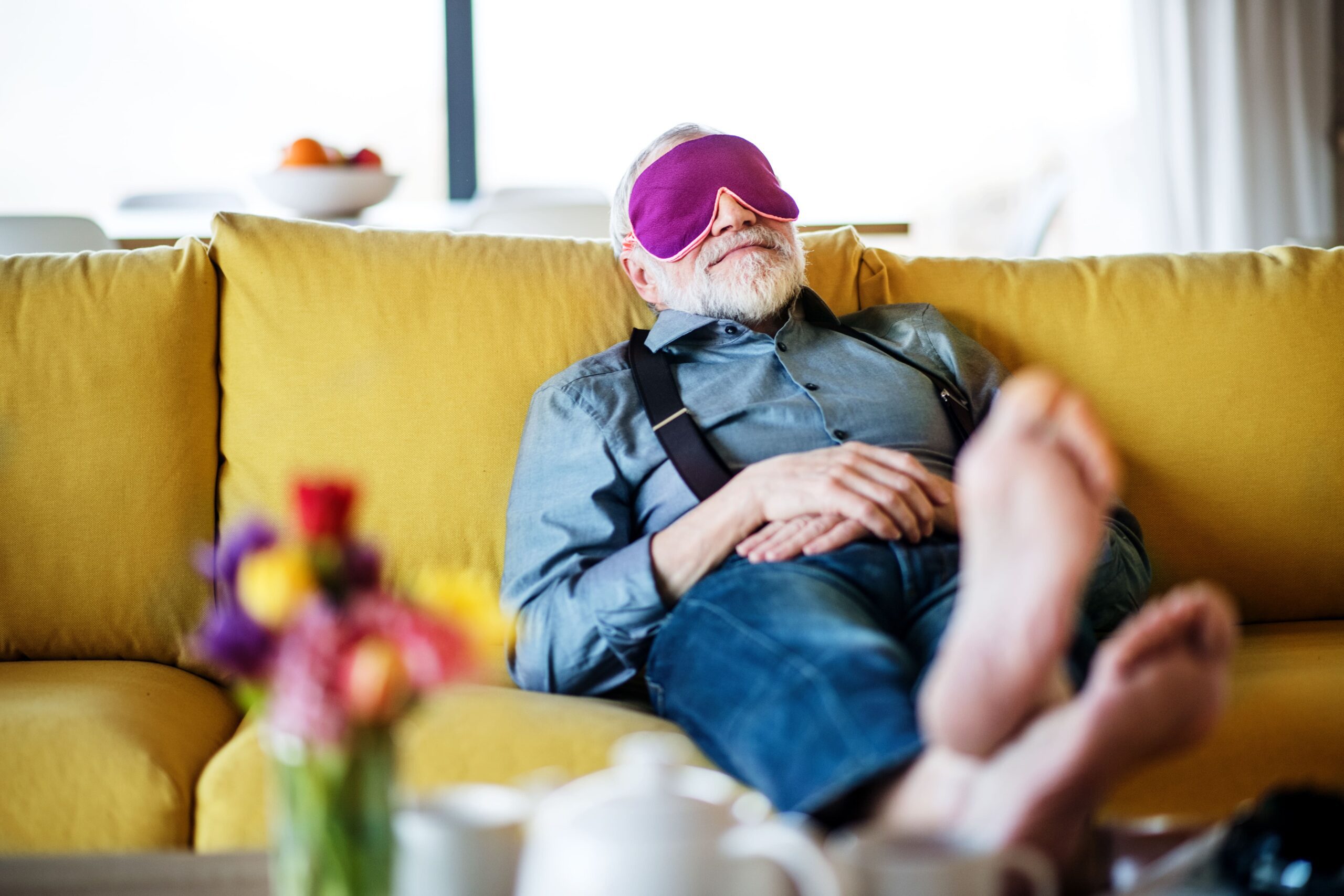 senior-man-with-eye-mask-lying-on-sofa-indoors-at-2024-10-18-17-40-25-utc-min
